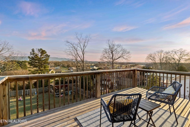 deck at dusk featuring fence