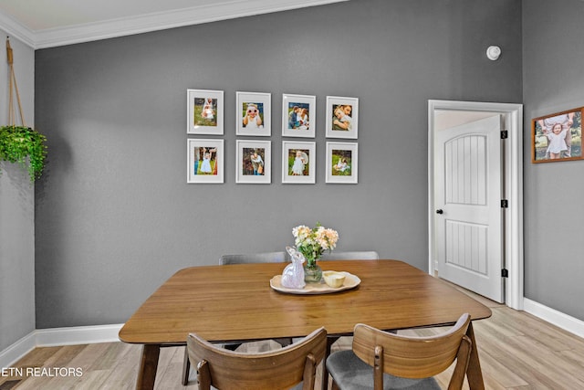 dining room with light wood-style floors, ornamental molding, and baseboards