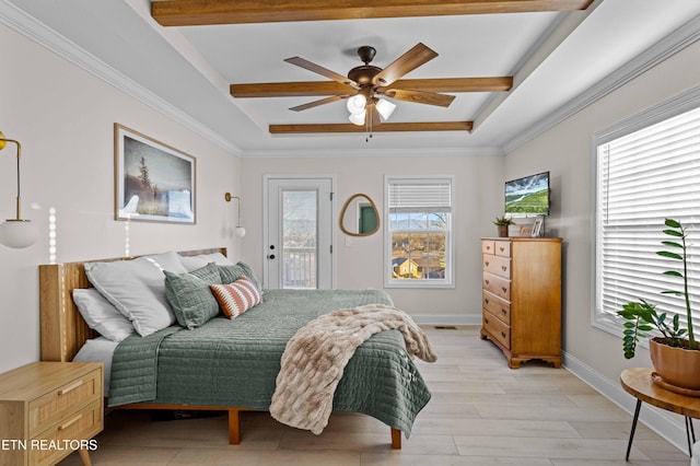 bedroom with multiple windows, a raised ceiling, and access to exterior