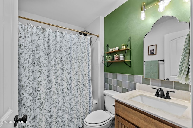 bathroom featuring toilet, a wainscoted wall, tile walls, and vanity