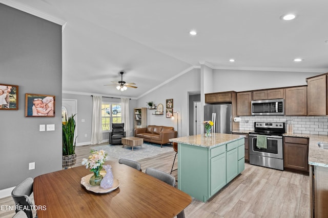 kitchen featuring light wood finished floors, decorative backsplash, appliances with stainless steel finishes, vaulted ceiling, and crown molding