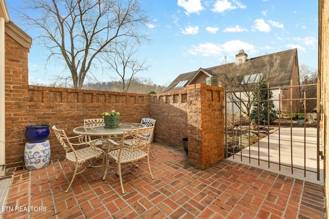 view of patio / terrace with a gate, outdoor dining area, and fence