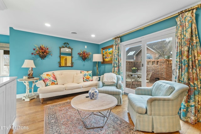 living area featuring visible vents, crown molding, baseboards, recessed lighting, and light wood-style flooring