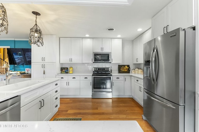 kitchen featuring a sink, stainless steel appliances, visible vents, and light countertops