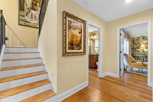 staircase featuring baseboards and wood finished floors