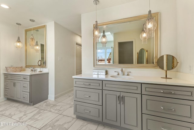 bathroom featuring marble finish floor, two vanities, and a sink