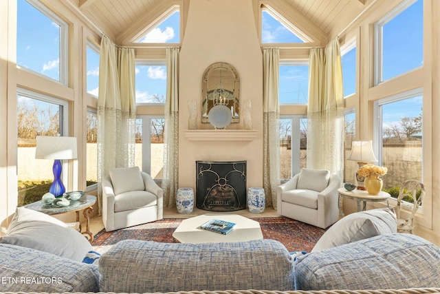 sunroom with lofted ceiling, wood ceiling, and a fireplace