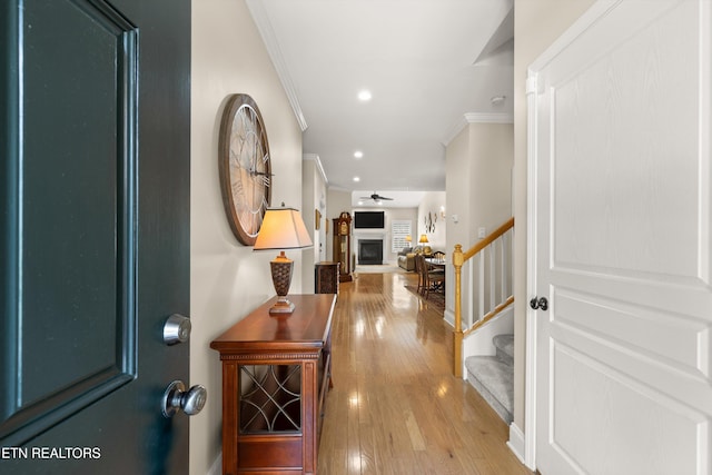 entrance foyer with wood-type flooring, stairway, ornamental molding, a fireplace, and recessed lighting