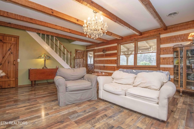 living area with a healthy amount of sunlight, stairs, visible vents, and wood finished floors