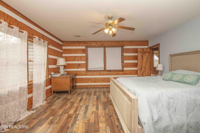 bedroom featuring multiple windows, wood-type flooring, and a ceiling fan