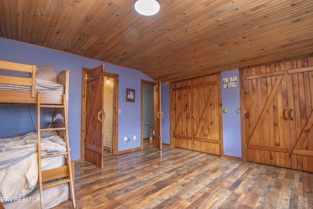 unfurnished bedroom with lofted ceiling, wood ceiling, baseboards, and wood finished floors