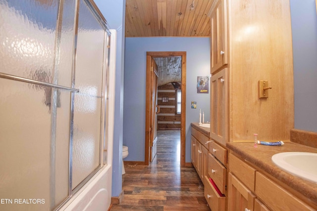 bathroom featuring toilet, shower / bath combination with glass door, wood ceiling, wood finished floors, and vanity