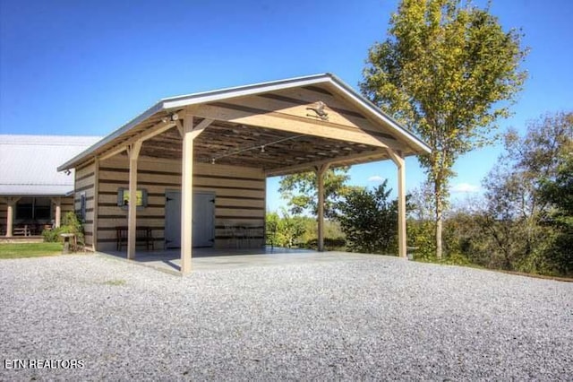 view of vehicle parking with a carport and gravel driveway