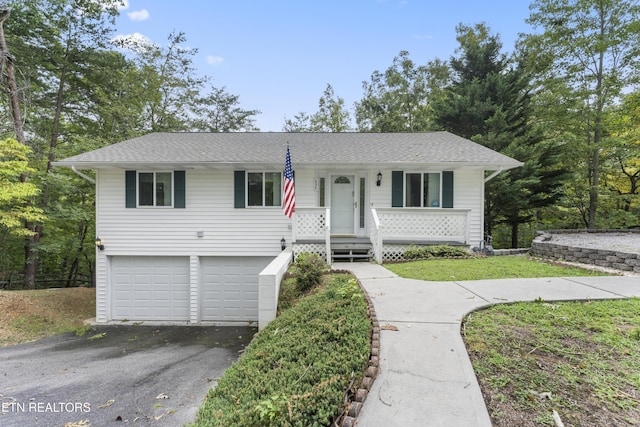 view of front of home featuring a garage, driveway, a porch, and roof with shingles