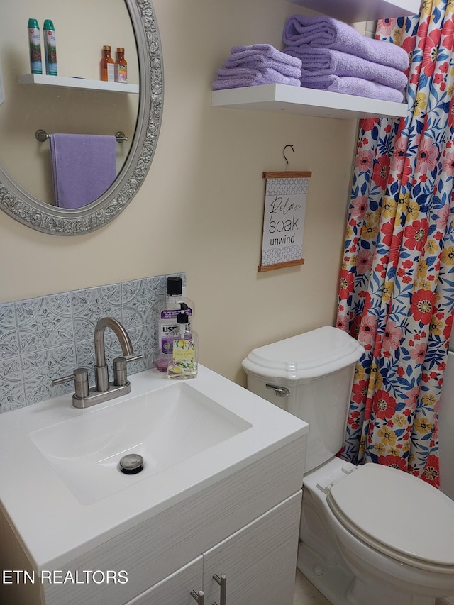 bathroom featuring backsplash, toilet, and vanity