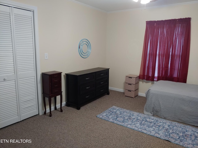 bedroom featuring ornamental molding, a closet, carpet, and baseboards