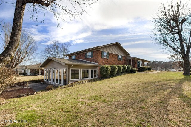 610 Hudson St, Athens, TN 37303 - back of property featuring a sunroom, a yard, and brick siding
