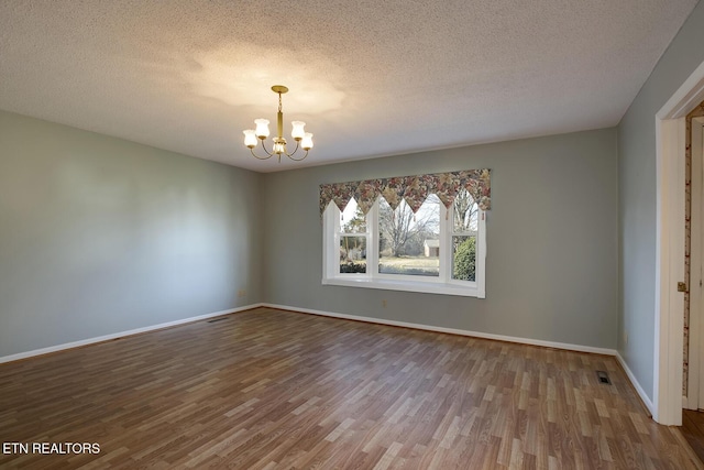 610 Hudson St, Athens, TN 37303 - spare room with baseboards, a textured ceiling, a chandelier, and wood finished floors