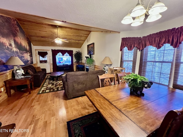 dining room with wooden ceiling, wood finished floors, vaulted ceiling, a textured ceiling, and ceiling fan with notable chandelier