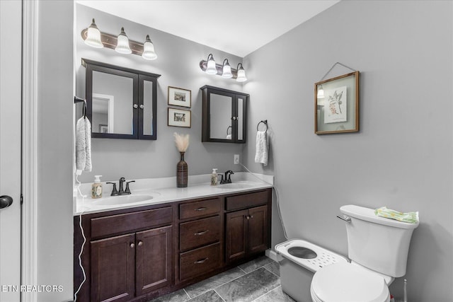 bathroom featuring a sink, toilet, and double vanity