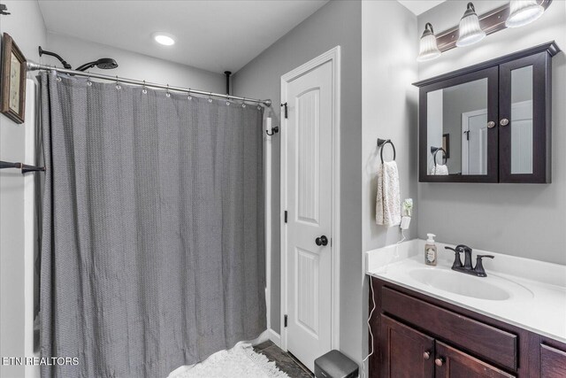 bathroom with curtained shower and vanity