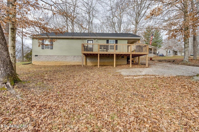 rear view of property featuring a deck and crawl space