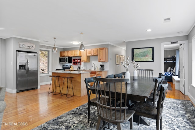 dining space with recessed lighting, visible vents, baseboards, ornamental molding, and light wood finished floors