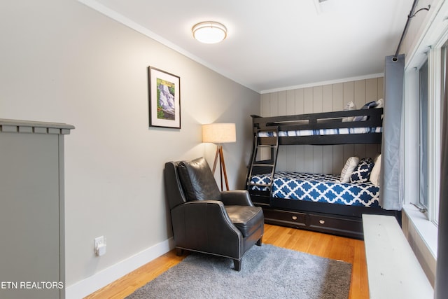 bedroom featuring crown molding, baseboards, and wood finished floors