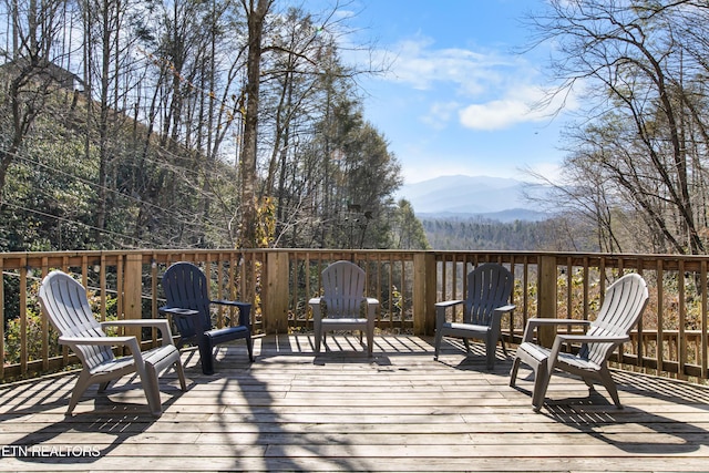 deck featuring a mountain view and a wooded view