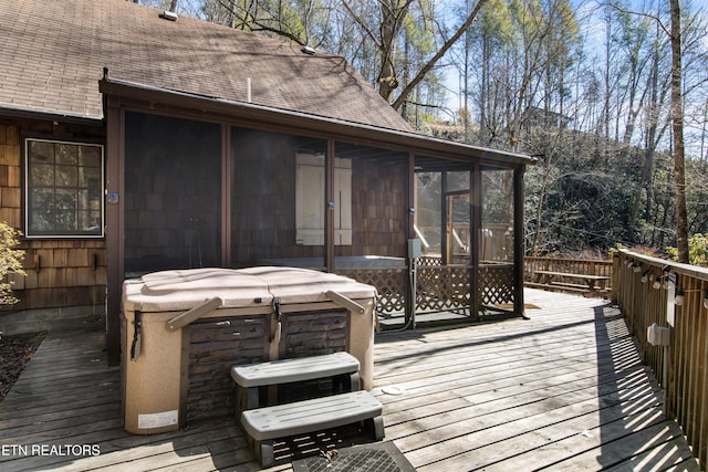 deck featuring a sunroom and a hot tub