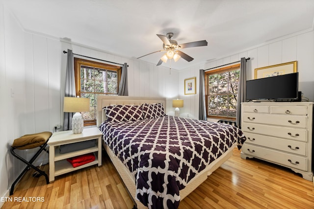 bedroom featuring multiple windows, light wood-style flooring, and a ceiling fan