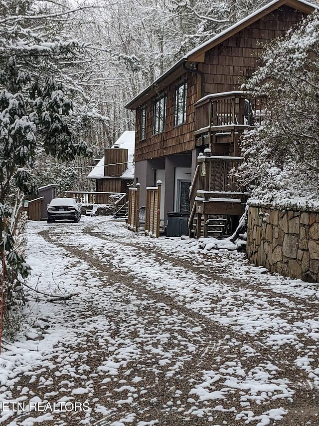 snow covered property featuring stairway