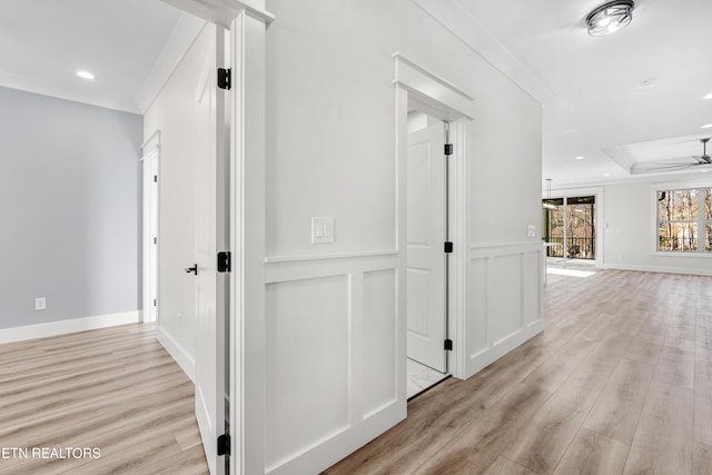 hall featuring recessed lighting, light wood-style flooring, ornamental molding, and a decorative wall