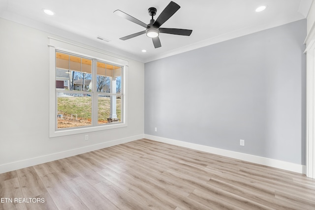 spare room with baseboards, visible vents, light wood finished floors, and ornamental molding