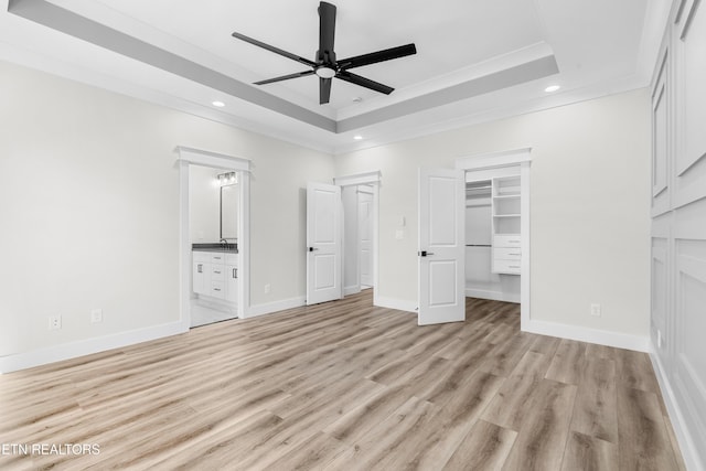 unfurnished bedroom featuring a raised ceiling, recessed lighting, baseboards, and light wood-type flooring