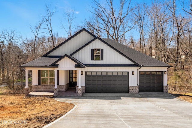 modern inspired farmhouse with driveway, covered porch, an attached garage, a shingled roof, and brick siding