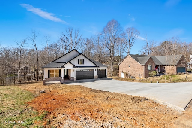 modern inspired farmhouse featuring brick siding, driveway, and a garage