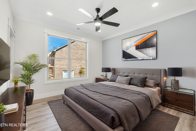 bedroom with visible vents, light wood-style flooring, crown molding, and baseboards