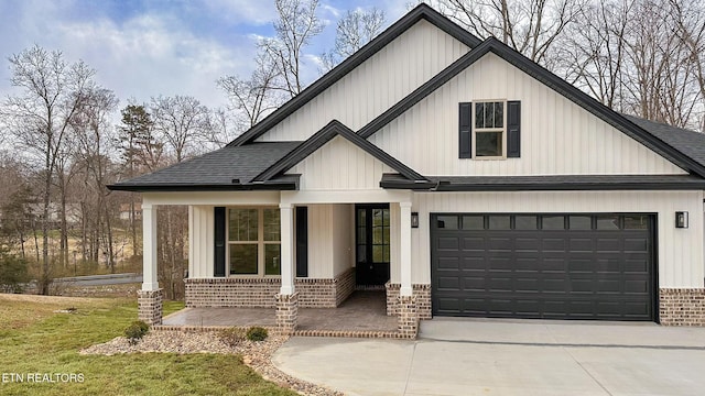 modern inspired farmhouse featuring a front yard, roof with shingles, a porch, concrete driveway, and brick siding