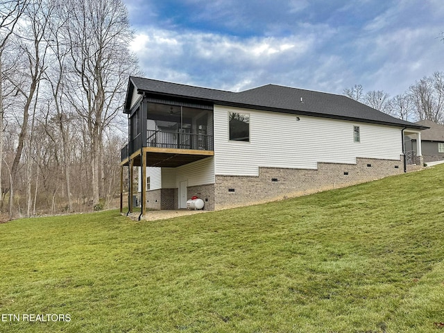 rear view of property featuring crawl space, a lawn, a patio area, and a sunroom