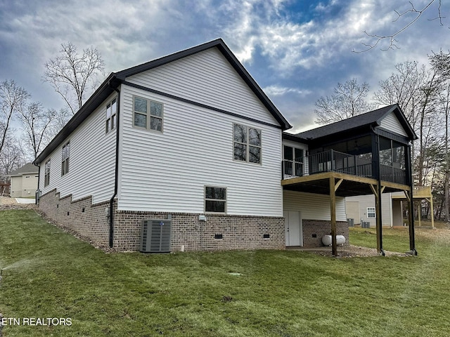 back of property featuring a yard, central AC, and a sunroom