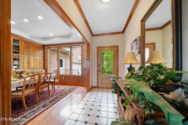 foyer entrance featuring a wainscoted wall, ornamental molding, recessed lighting, and light wood-style flooring