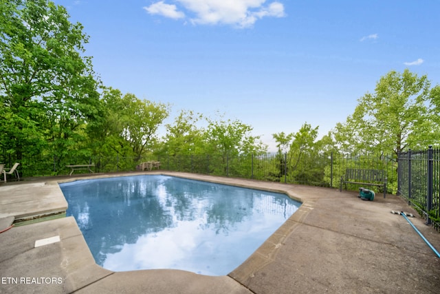 view of swimming pool featuring fence, a fenced in pool, and a patio area