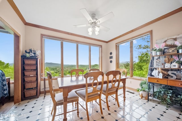dining space with crown molding, ceiling fan, baseboards, light floors, and a mountain view