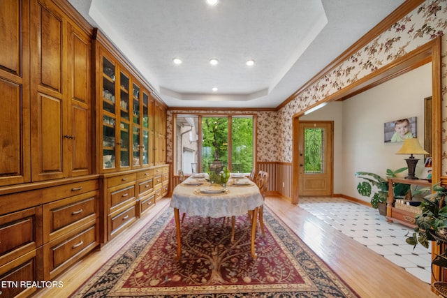 dining space featuring wainscoting, light wood-style floors, wallpapered walls, recessed lighting, and a tray ceiling