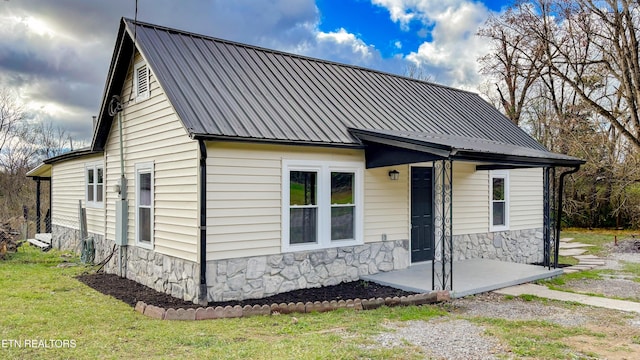 view of front facade featuring stone siding and metal roof