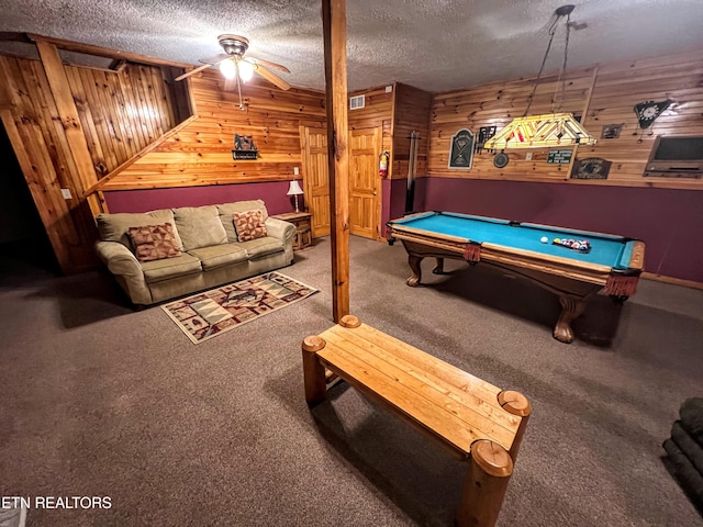 rec room featuring wood walls, carpet, and a textured ceiling