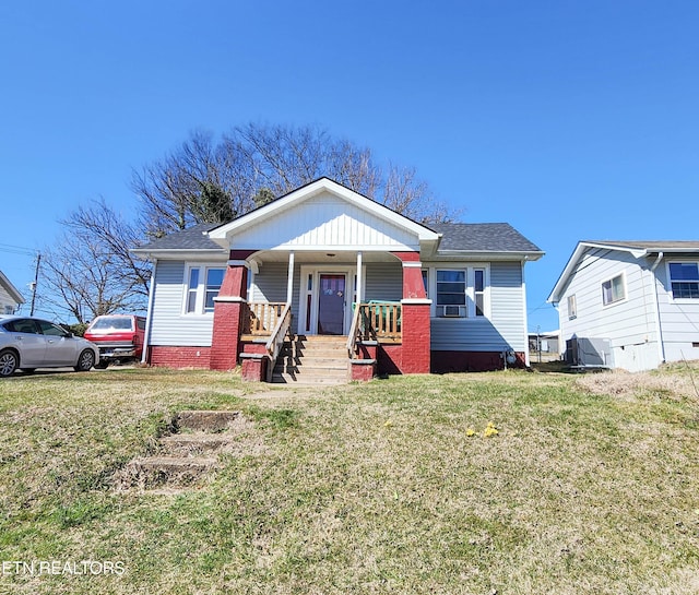 view of front of home with a porch, a front yard, and roof with shingles