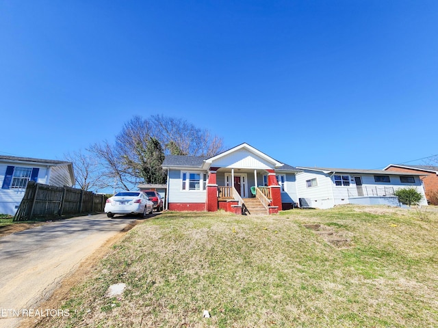 view of front of home featuring fence, a porch, concrete driveway, and a front yard