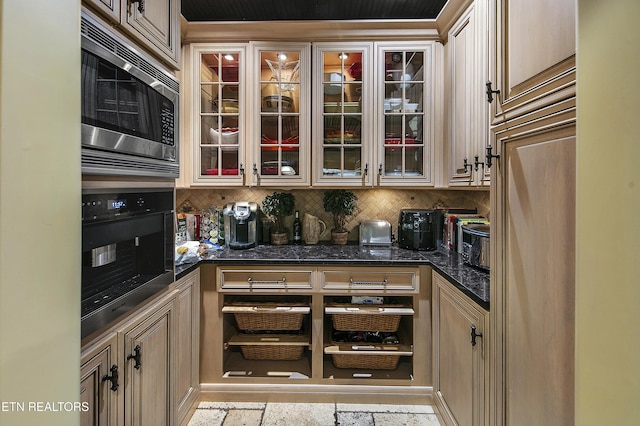 kitchen with glass insert cabinets, tasteful backsplash, appliances with stainless steel finishes, and dark stone counters